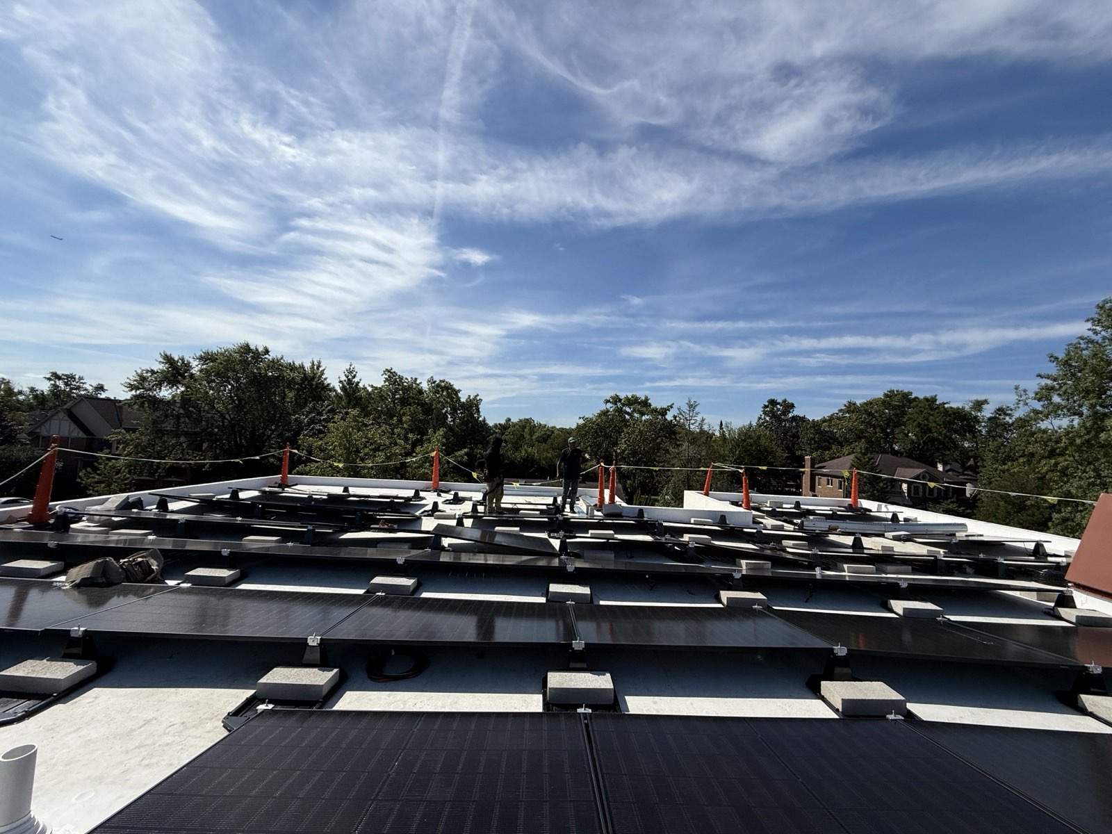 Green Attic crew installing a ballasted solar array on a white flat roof in Chicagoland